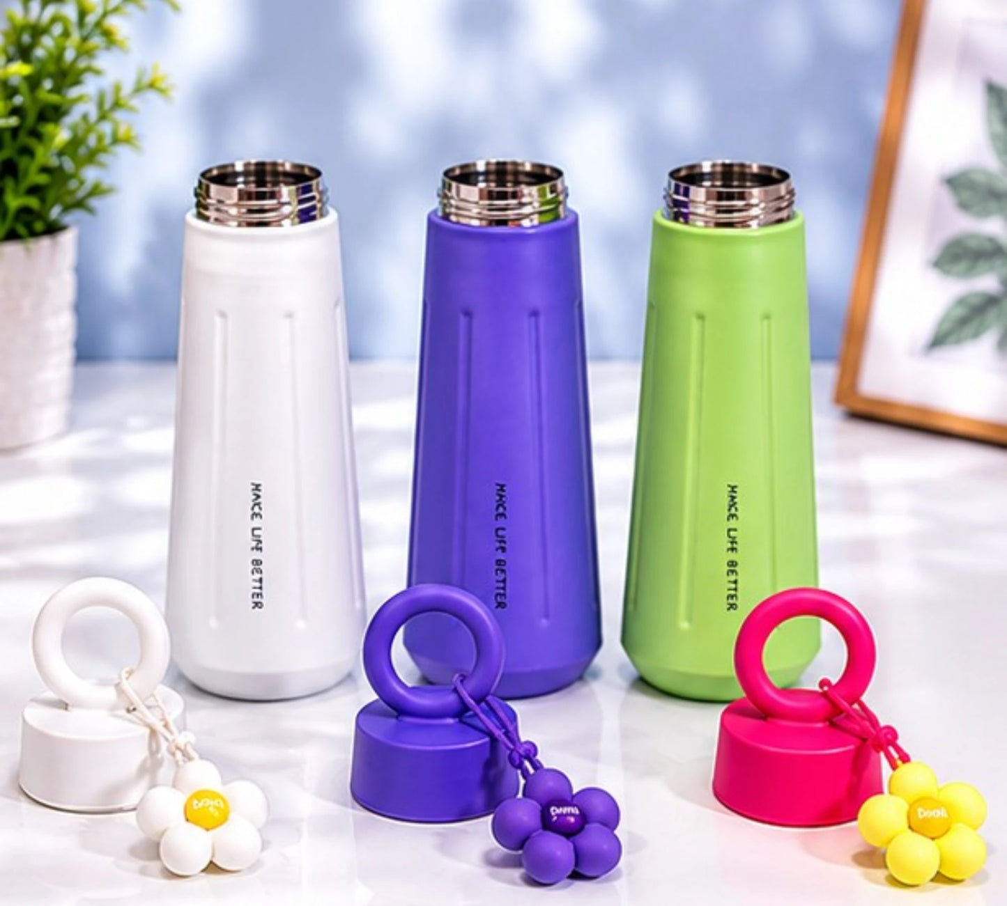 Cute stainless steel insulated water bottle with daisy flower charm and carry handle.