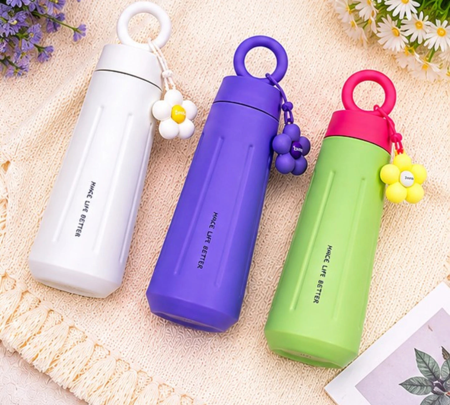 Cute stainless steel insulated water bottle with daisy flower charm and carry handle.
