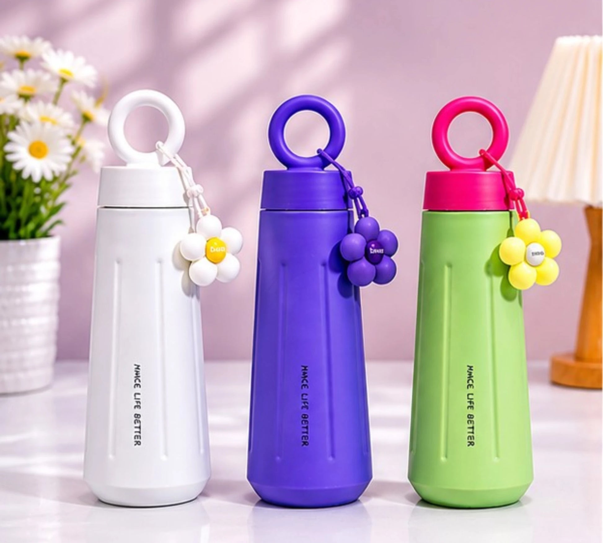 Cute stainless steel insulated water bottle with daisy flower charm and carry handle.